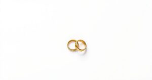 A stylised illustration depicting two separate wedding rings on a table, symbolising divorce and independence.