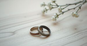 A couple's broken wedding ring lies on a wooden table, symbolising the end of a relationship with muted colours.