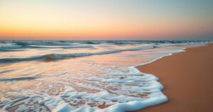 A serene beach scene with soft waves, golden sand, and a distant sunset, symbolizing privacy and tranquility.